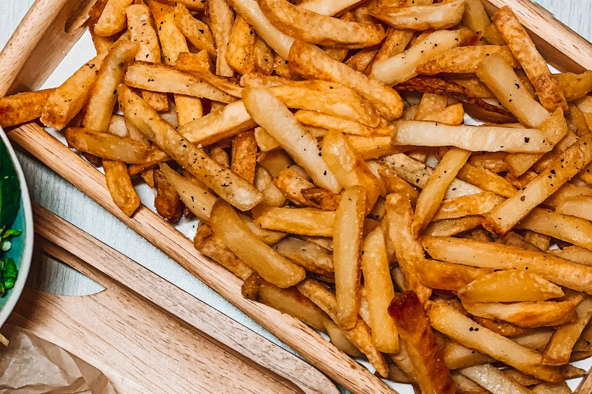 Batatas fritas douradas em cesta de metal, ilustração da categoria, não é packshot da EAF45