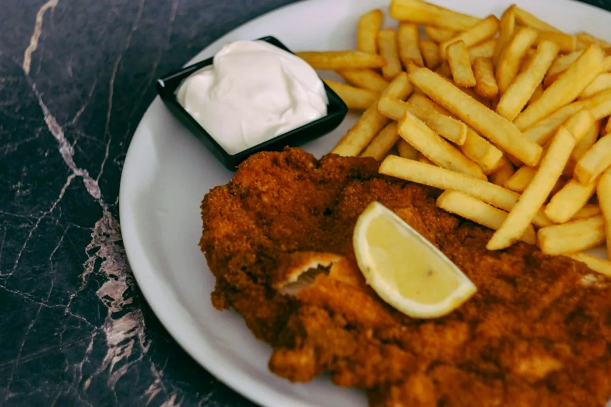 Porção de frango crocante com batatas rústicas douradas, ilustrando alimentos preparados em airfryer