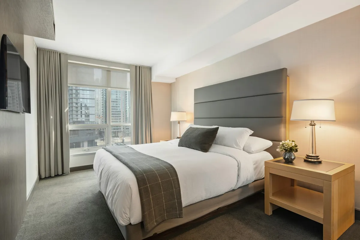 Quarto com cama de casal e lençol claro, ilustração de categoria de colchões, não é packshot da Sleep Max D28