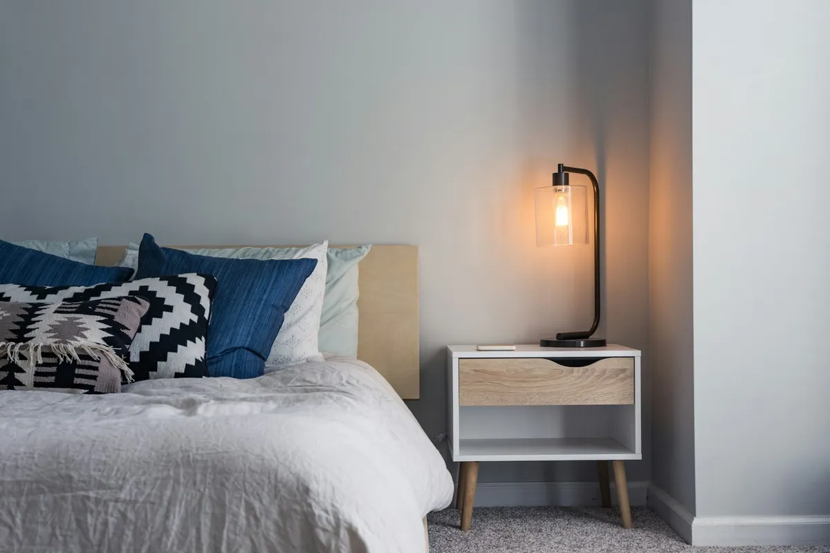 Quarto com cama de casal feita, lençóis claros e luz da janela, ilustração de categoria de colchões, não é packshot do Luuna Support