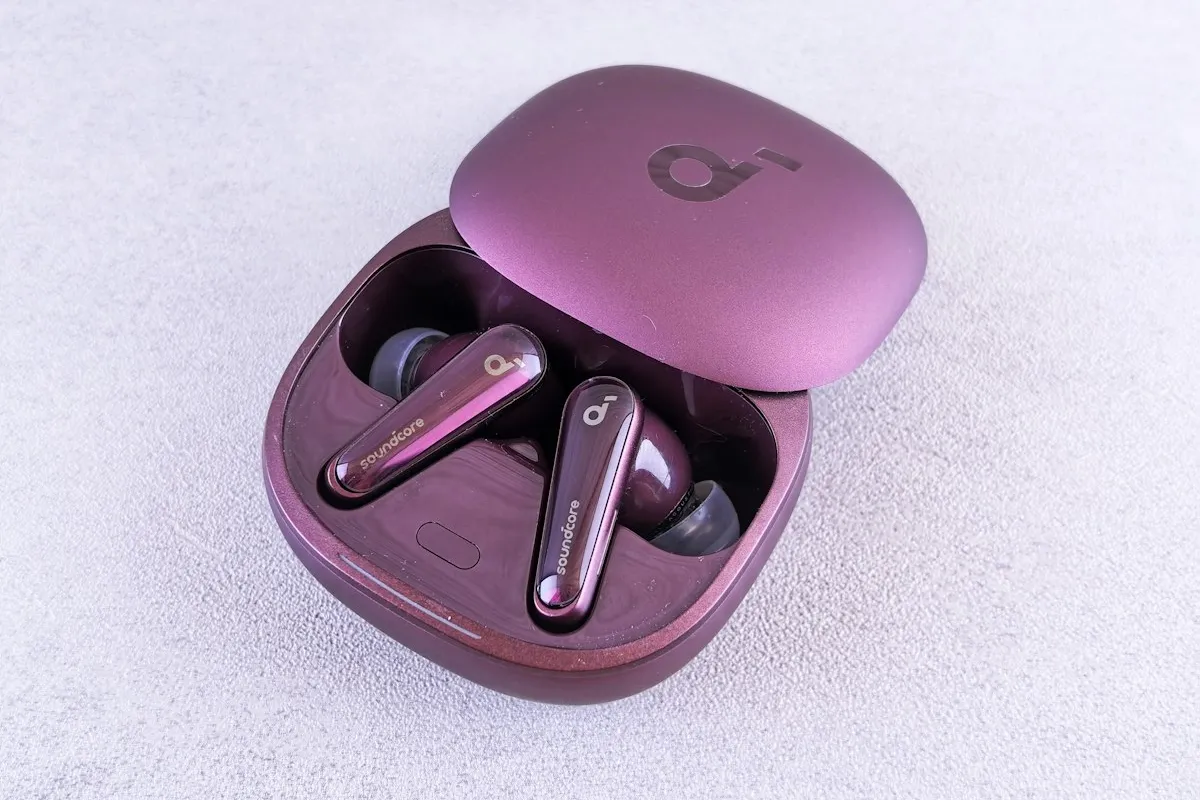 Fones de ouvido sem fio intra-auriculares com estojo de recarga sobre mesa clara