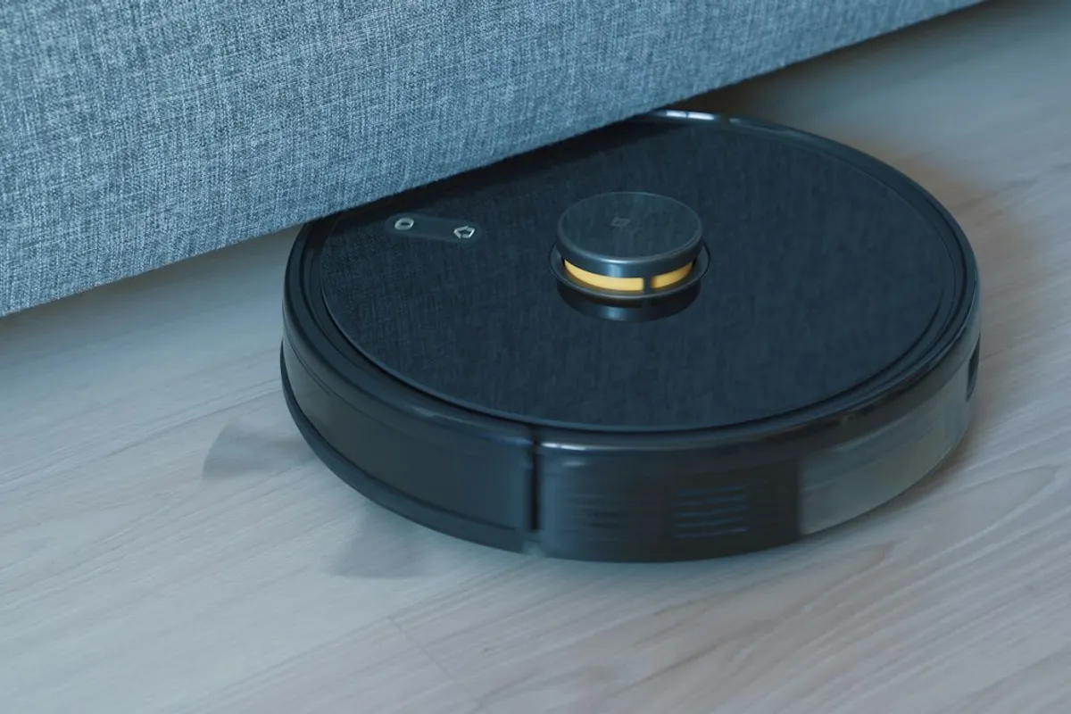 Robô aspirador preto em piso de madeira, ilustração da categoria, não é packshot do Philco PAS23
