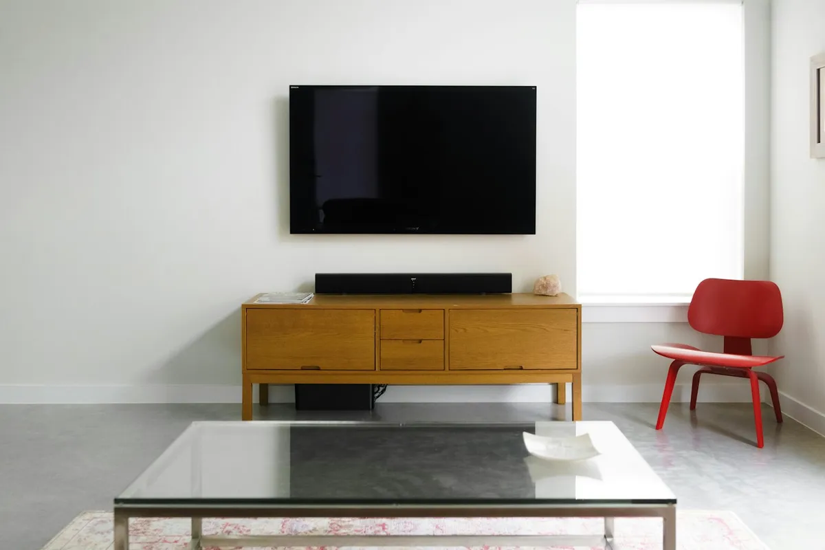 Televisor de tela plana fixado na parede de sala contemporânea, ilustrando Smart TV em ambiente doméstico